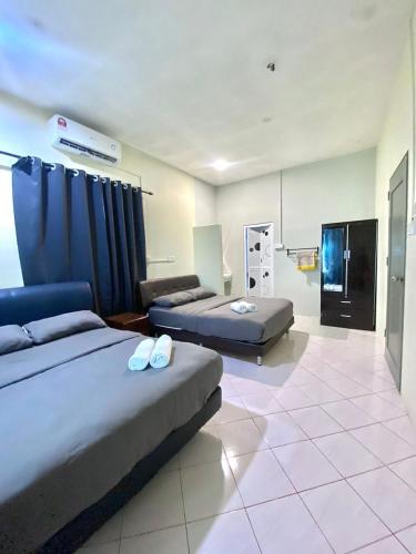 a hospital room with two beds and a tv at Casaria Beach in Paka