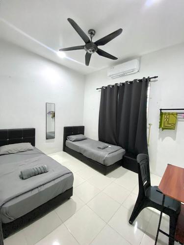 a bedroom with a bed and a ceiling fan at Casaria Homestay Paka in Paka