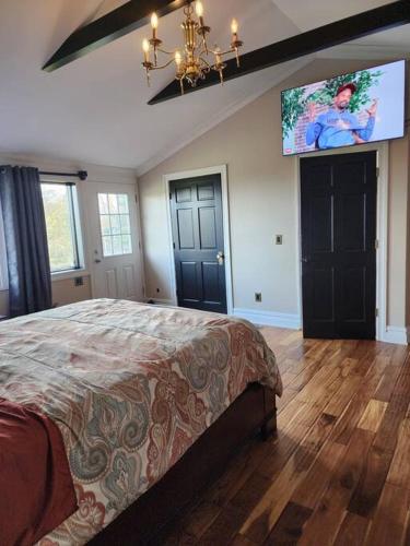 a bedroom with a bed and a flat screen tv at Beautiful home with mountain top views with an EV and NEMA connection!! in Poughkeepsie