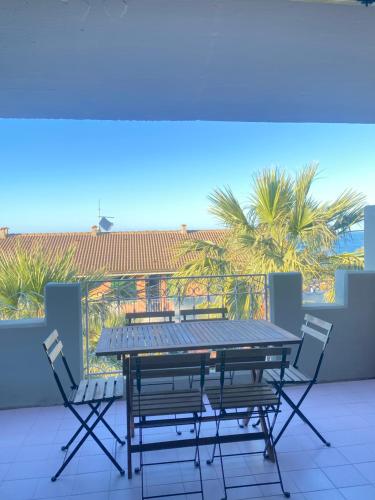 a table and chairs on a balcony with palm trees at Coastal Dream in Finale