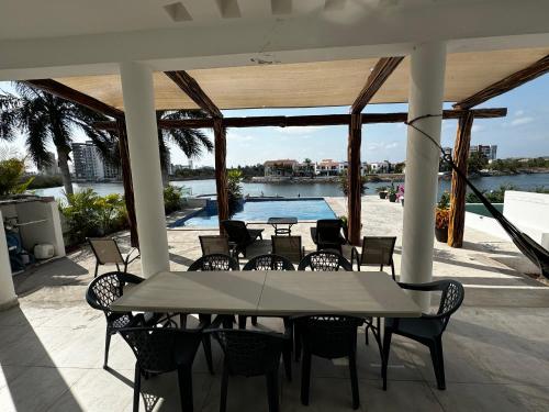 a patio with a table and chairs and a pool at Casa Isla Marina Vista al Mar 20 Personas in Mazatlán