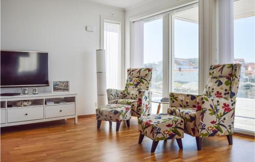a living room with two chairs and a flat screen tv at 2 Bedroom Cozy Apartment In Rönnäng in Rönnäng