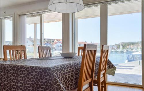 a dining room with a table with chairs and windows at 2 Bedroom Cozy Apartment In Rönnäng in Rönnäng