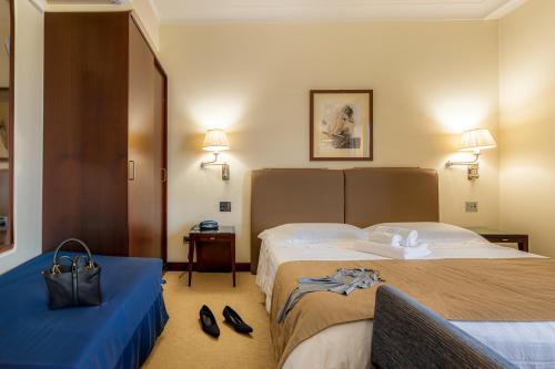 a hotel room with two beds and shoes on the floor at Hotel Cala Del Porto in Vibo Valentia Marina