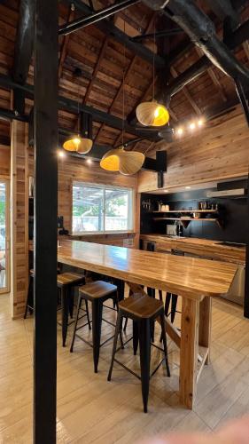 a dining room with a large wooden table and chairs at ケーブキャビン シービュー BBQ ピザ サウナ ホットタブ - Cave Cabin Chiba Seaview BBQ Pizza Sauna Hot-tub in Kobama