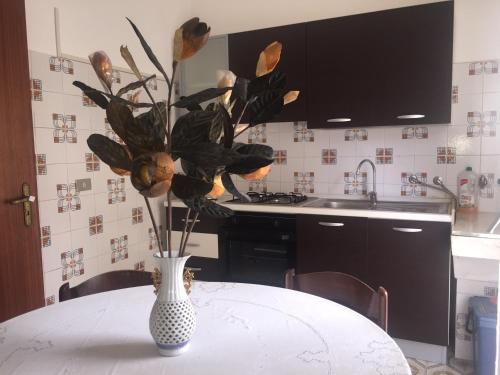 a vase with flowers on a table in a kitchen at B e B CASA DA PINA in Ragusa