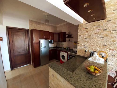 a kitchen with a refrigerator and a counter with a bowl of fruit at Chalet Marina Wadi Degla Families Only Pool view 2nd floor with Roof 6 adults in Ain Sokhna
