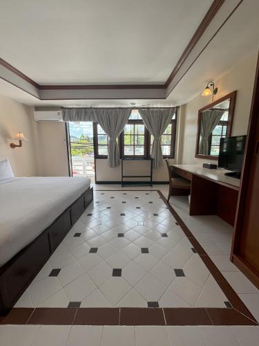 a bedroom with a bed and a desk and a television at Sunset Mansion in Patong Beach