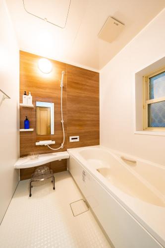 a white bathroom with a tub and a sink at 50, Nakano 1, Entire house for rent, 中野1丁目 in Tokyo