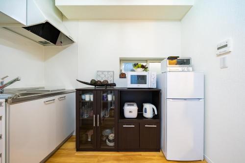 a kitchen with a microwave and a refrigerator at 50, Nakano 1, Entire house for rent, 中野1丁目 in Tokyo