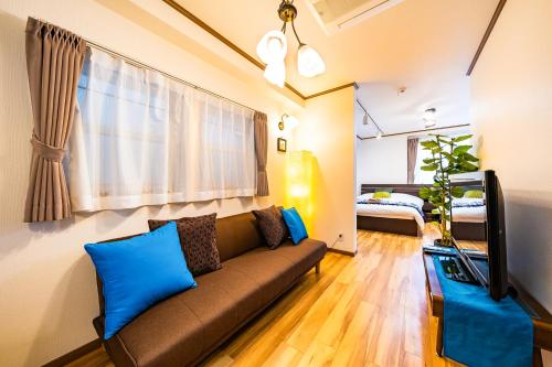 a living room with a brown couch and blue pillows at 50, Nakano 1, Entire house for rent, 中野1丁目 in Tokyo