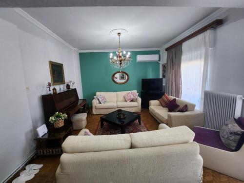 a living room with two couches and a chandelier at Maria's House in Alexandroupoli