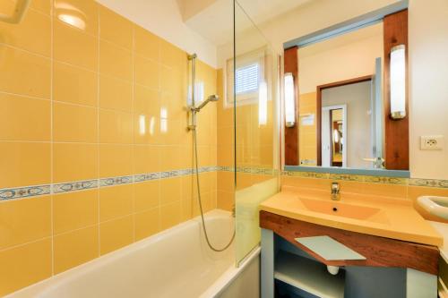 ein Badezimmer mit Waschbecken, Badewanne und Spiegel in der Unterkunft Résidence Belle Dune - maeva Home - Appartement 2 pièces 4 personnes - Sélection MAE-3751 in Fort-Mahon-Plage