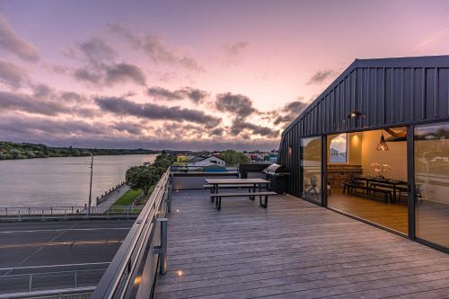 a house with a deck with a view of the water at Johnston Apartments - Award-winning building, Your unforgettable stay in Whanganui
