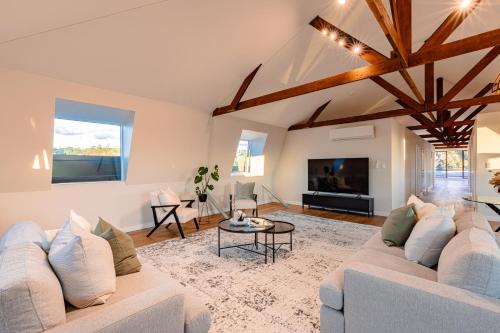 a living room with a couch and a tv at Johnston Apartments - Award-winning building, Your unforgettable stay in Whanganui
