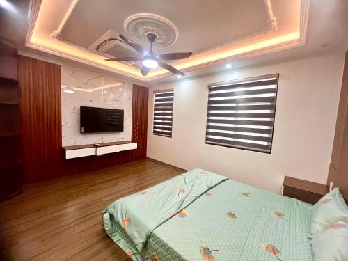 a bedroom with a ceiling fan and a television at HPT Home I Hoàng Huy Riverside Apartment-Homestay Hải Phòng in Hai Phong