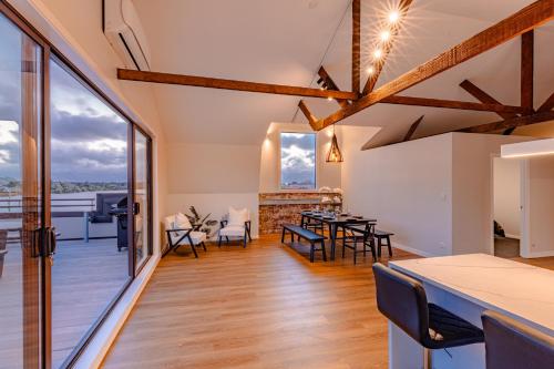 a living room with a table and chairs and a balcony at Johnston Apartments - Award-winning building, Your unforgettable stay in Whanganui