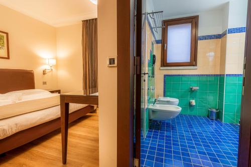 a bathroom with a bed a toilet and a sink at Hotel Cala Del Porto in Vibo Valentia Marina