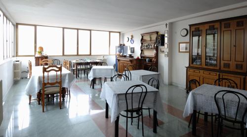 a kitchen and dining room with tables and chairs at Albergo Imperiale in Livorno