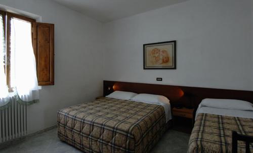 a hotel room with two beds and a window at Albergo Imperiale in Livorno