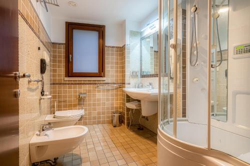 a bathroom with two toilets and a sink and a shower at Hotel Cala Del Porto in Vibo Valentia Marina