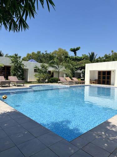 a large swimming pool with blue water at Fukuchani Inn Hotel in Kigongoni