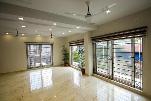 a large room with large windows and a room with a plant at K Grandeur Hotels in Cochin