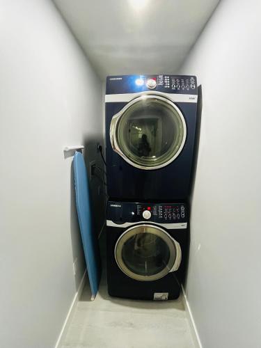 a washer and dryer in a corner of a room at Amy's 2-Bedroom Residence in Calgary