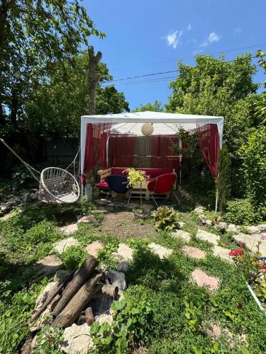 a gazebo with a couch and chairs in a yard at Guest house Me and grandfather-მე და პაპა in Dedoplis Tskaro