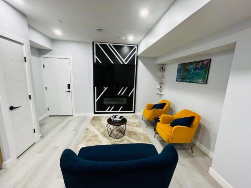 a living room with two chairs and a couch at Amy's 2-Bedroom Residence in Calgary