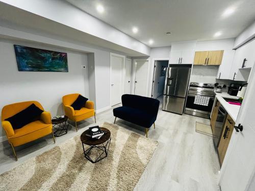 Il comprend un salon avec deux chaises et une cuisine. dans l'établissement Amy's 2-Bedroom Residence, à Calgary