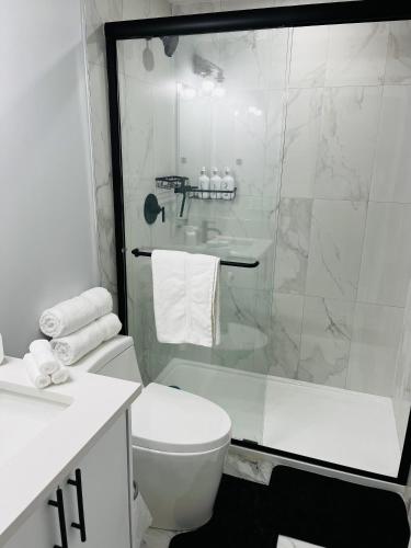 a bathroom with a toilet and a glass shower at Amy's 2-Bedroom Residence in Calgary