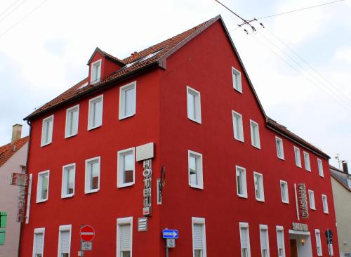 ein rotes Gebäude mit weißen Fenstern und einem Stoppschild in der Unterkunft Alpha & Omega Hotel in Stuttgart