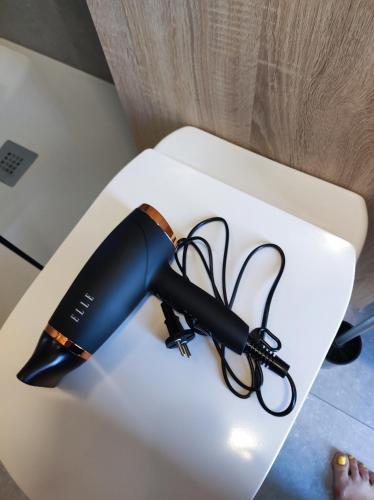 a black hair dryer sitting on a white table at Little Tiny Village Haus 2 in Fußach