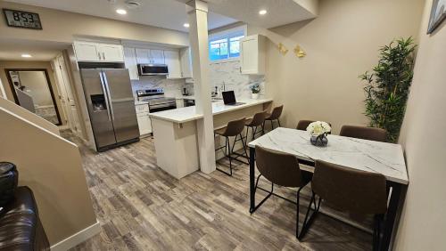 a kitchen and dining room with a table and chairs at Luxury Basement Suite with 2 Bedrooms, 2 Queen Beds, Free Wi-Fi, and Free Parking in Calgary