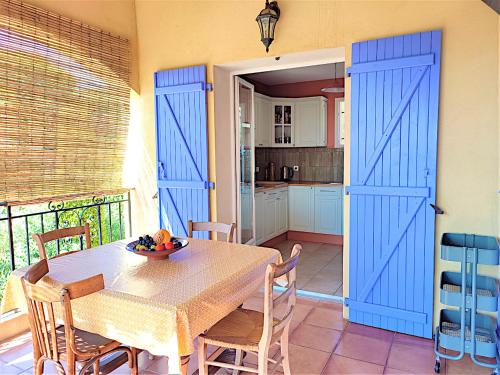 d'une salle à manger avec une table et des portes bleues. dans l'établissement Villa avec piscine privée - vue sur vignoble, à 8 min de la plage, à Fréjus