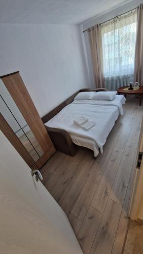 a bedroom with a bed and a wooden floor at Apartament Coco in Codlea
