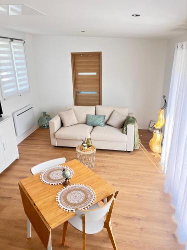 un salon avec une table et un canapé dans l'établissement La belle Iris, à Longueau