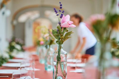 a table with a vase with flowers in it at Engelwirt Hotel & Apartments in Berching