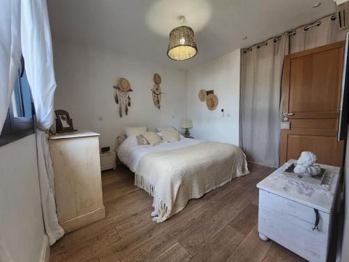 une chambre avec un lit blanc et un parquet dans l'établissement VILLA PROVENÇALE entre ANTIBES et CANNES, à Vallauris