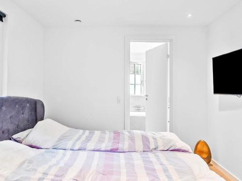 Un dormitorio con una cama y un televisor en una pared. en 5 star holiday home in Væggerløse-By Traum, en Bøtø By