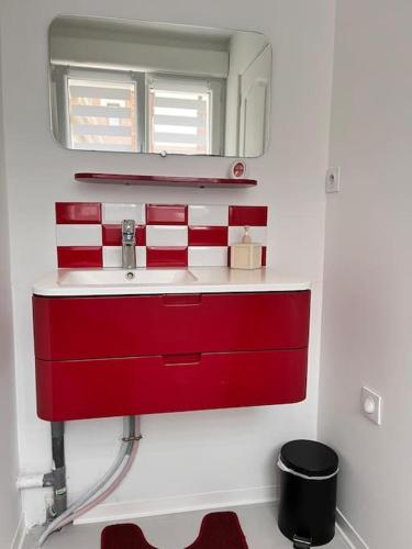 La salle de bains est pourvue d'un lavabo rouge et d'un miroir. dans l'établissement L' authentique Clément, à Longueau