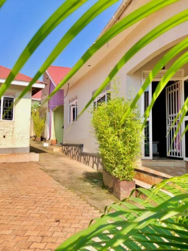 a white house with a red roof at Airport Shoebill Hotel in Entebbe