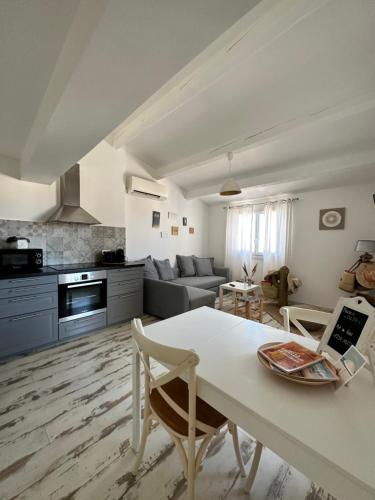 une cuisine et un salon avec une table et un canapé dans l'établissement Appartement cosy Le Bohème, à 300m des plages LOCAMARGUE, à Saintes-Maries-de-la-Mer