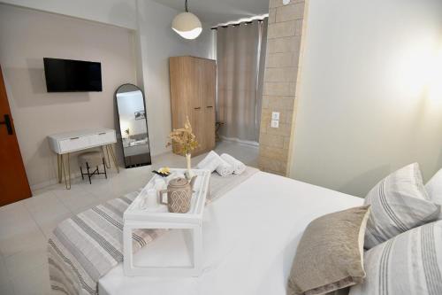a white bedroom with a white bed and a mirror at Melia Casa in Rhodes Town