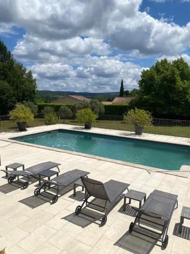 - une piscine avec 4 chaises et un groupe dans l'établissement Villa spacieuse proche de Marseille avec jardin et piscine privée, à La Tour-dʼAigues