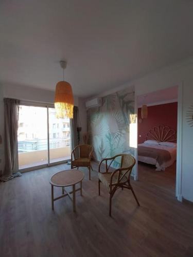 un salon avec une table et des chaises et un lit dans l'établissement Joli 2 pièces tendance 5 mns de la plage, à Torcy