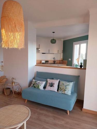 un salon avec un canapé bleu et une table dans l'établissement Joli 2 pièces tendance 5 mns de la plage, à Torcy