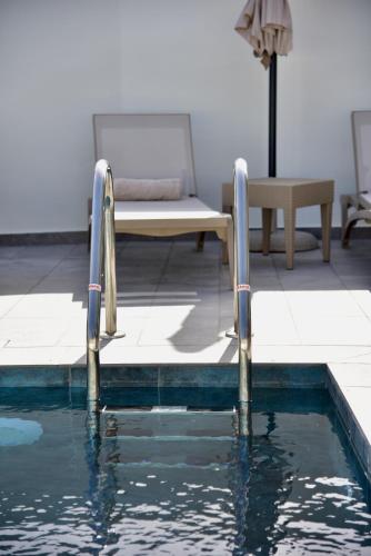 a swimming pool with two metal rails in the water at Melia Casa in Rhodes Town
