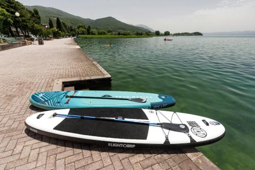 two paddle boards sitting on a dock in the water at Bogdanoski Studios & Guest Rooms in Ohrid